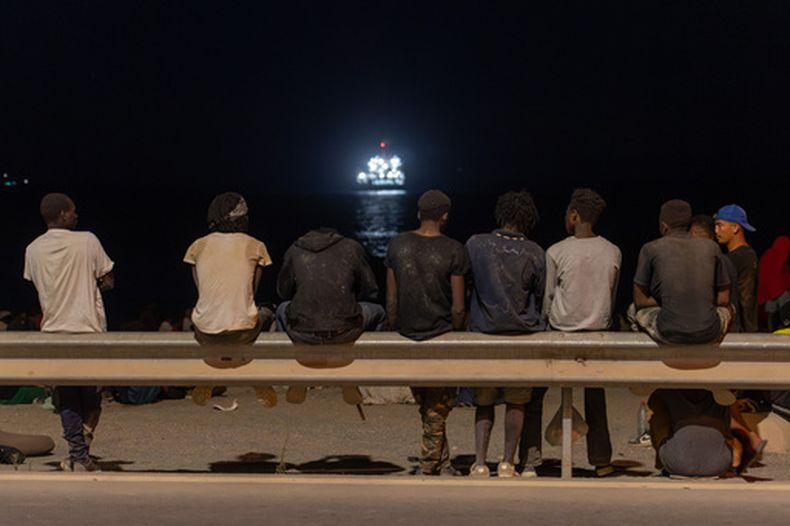 Migrantes que cruzaron a España desde Marruecos se reúnen en una playa en el enclave español de Ceuta, el domingo 2 de agosto de 2026. (AP Foto/Antonio Sempere)