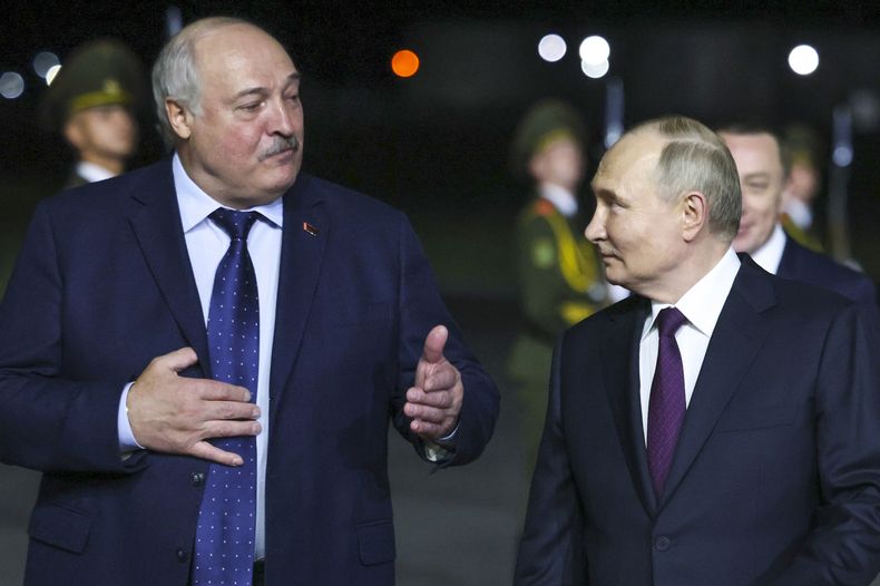 El presidente ruso Vladímir Putin, a la derecha, escucha al presidente bielorruso Alexander Lukashenko mientras caminan el jueves 23 de mayo de 2024 tras la llegada de Putin al aeropuerto internacional de Minsk, Bielorrusia. (Mikhail Metzel, Sputnik, foto compartida del Kremlin vía AP)