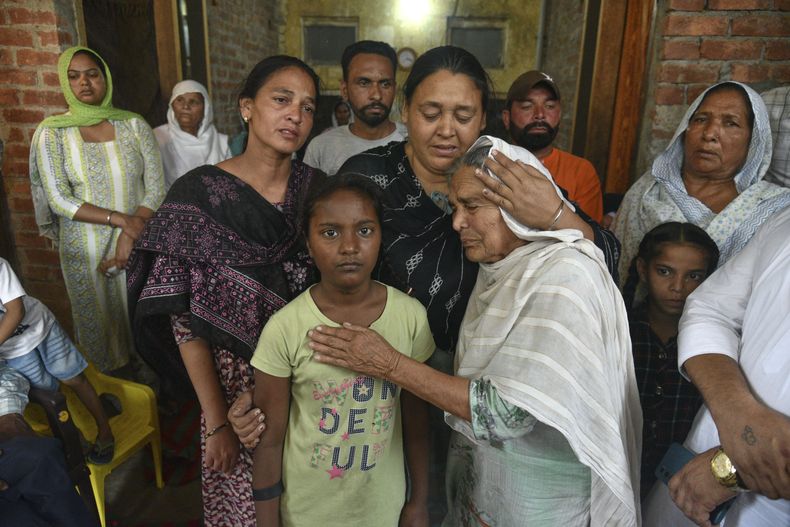 Familiares de Sikander, que murió tras consumir licor tóxico en el poblado de Majitha, a las afueras de Amritsar, India, el martes 13 de mayo de 2025. (AP Foto/Prabhjot Gill)