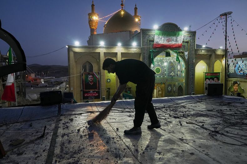 Un trabajador limpia un área del complejo Gran Hosseiniyeh, con la mezquita en el fondo que, según autoridades, fue alcanzada por ataques aéreos lanzados el martes por Estados Unidos e Israel, en Zanjan, Irán, el sábado 4 de abril de 2026. (AP Foto/Francisco Seco)