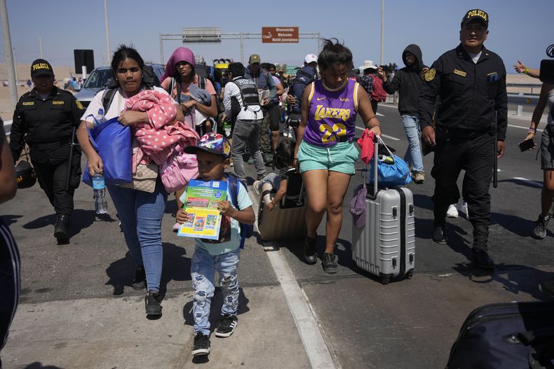 Migrantes venezolanos escoltados por la policía peruana hacia una oficina de migración en la frontera con Chile, en Tacna, Perú, el viernes 28 de abril de 2023. La crisis migratoria en la frontera entre Chile y Perú se intensificó el jueves con cientos de migrantes que quedaron varados en el límite fronterizo, sin poder cruzar a Perú. (AP Foto/Martín Mejía)