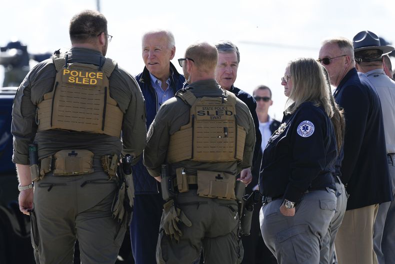 El presidente Joe Biden y el gobernador de Carolina del Norte, el demócrata Roy Cooper, saludan a los socorristas tras recorrer zonas afectadas por el huracán Helene, el miércoles 2 de octubre de 2024, en el aeropuerto de Greenville, Carolina del Sur. (AP Foto/Susan Walsh)