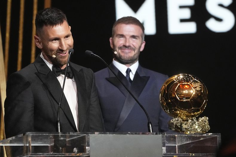 El co propietario del Inter Miami y ex estrella del fútbol mundial David Beckham (derecha) sonríe mientras EL astro argentino Lionel Messi recibe el Balón de Oro 2023 en la 67ma ceremonia de premiación del Balón de Oro, en el Theatre du Chatelet en París, el lunes 30 de octubre de 2023. (AP Foto/Michel Euler)
