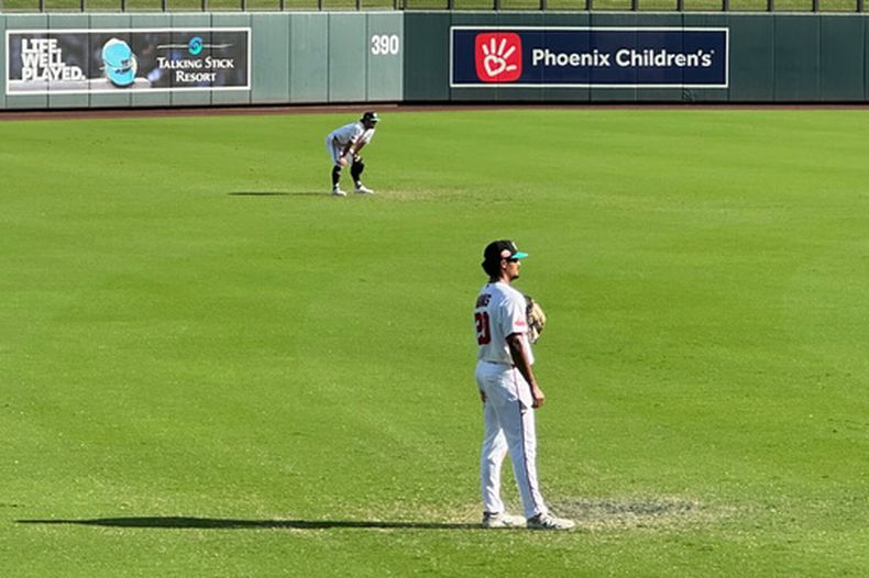 En una foto tomada con un celular de los jardineros de Salt River Teo Banks y Kyle DeBarge toman sus posiciones en el encuentro en el que la MLB experimentó con las reglas del jardín el jueves 22 de octubre del 2026. (AP Foto/David Brandt)