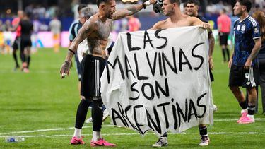 El volante argentino Giovani Lo Celso sostiene una pancarta con la frase Las Malvinas son argentinas junto a su compañero Nicolás Otamendi al término de la victoria 2-1 ante Inglaterra en las semifinales de la Copa del Mundo, el miércoles 15 de julio de 2026, en Atlanta. (AP Foto/Rebecca Blackwell)