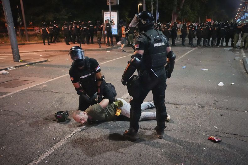Agentes de la policía antimotines detienen a un hombre tras cargar contra manifestantes al final de una protesta antigubernamental que exigía la convocatoria de elecciones anticipadas en medio de una oleada de movilizaciones contra la corrupción que han sacudido al gobierno del presidente Aleksandar Vucic, en Belgrado, Serbia, el 28 de junio de 2025. (AP Foto/Darko Vojinovic)