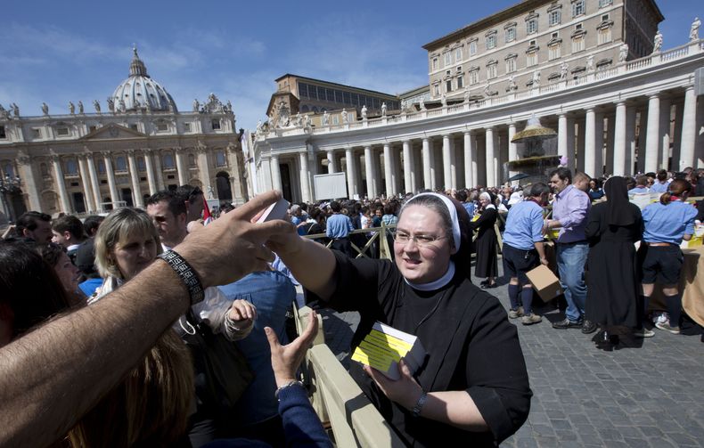 Una monja distribuye copias de los Evangelios a cientos de fieles en la Plaza de San Pedro el domingo 6 de abril de 2014. El papa Francisco se los obsequi&oacute; con la idea de que los tengan a la mano y los lean todos los d&iacute;as. (Foto AP/Alessandr