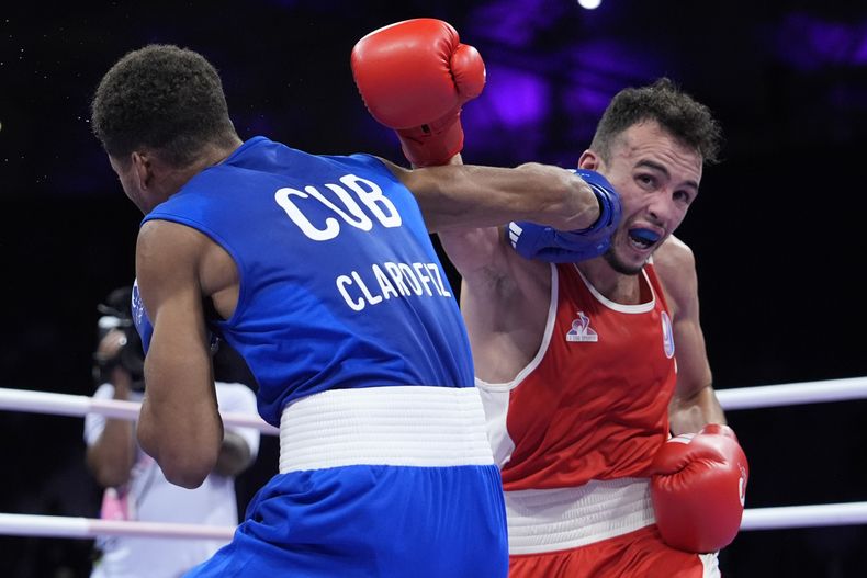 El francés Billal Bennama, de rojo, ante el cubano Alejandro Claro, en su combate de cuartos de final de peso mosca de los Juegos Olímpicos, el viernes 2 de agosto de 2024, en Villepinte, Francia. (AP Foto/Ariana Cubillos)