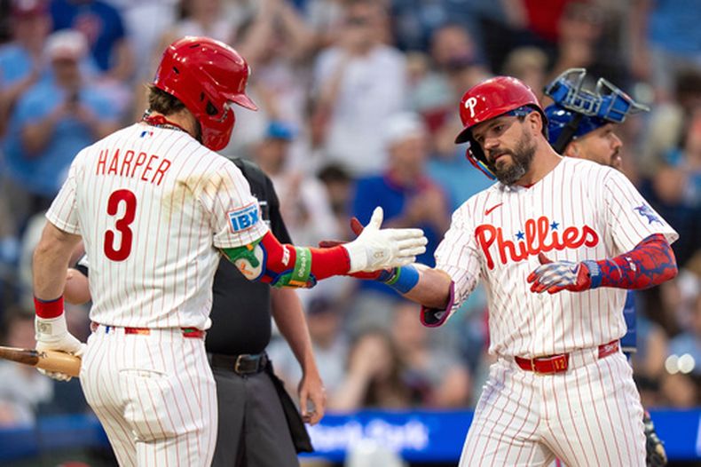 Kyle Schwarber (al frente, derecha), de los Filis de Filadelfia, celebra tras conectar un jonrón junto a Bryce Harper (3) durante la tercera entrada de un partido de béisbol contra los Mets de Nueva York, el sábado 20 de junio de 2026, en Filadelfia. (Foto AP/Chris Szagola)