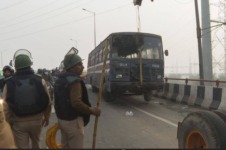 La policía levanta un vehículo para levantar una barricada en una autovía en Ghazipur, cerca de Nueva Delhi, para frenar a miles una marcha de agricultores que pretenden entrar en la capital de India, el 13 de febrero de 2024. (AP Foto/Shonal Ganguly)