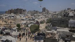 Palestinos corren para recoger ayuda humanitaria lanzada con paracaídas desde el aire, en la Ciudad de Gaza, en el norte de la Franja de Gaza, el 7 de agosto de 2025. (AP Foto/Jehad Alshrafi)