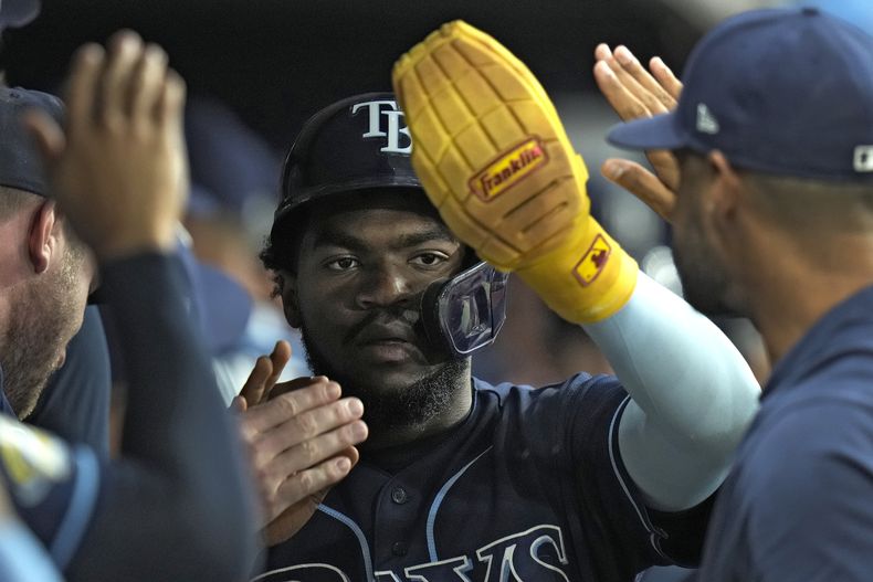 El venezolano Osleivis Basabe de los Rays de Tampa Bay (centro) celebra en el banquillo luego de anotar en un sencillo de dos carreras de su compatriota René Pinto ante los Angelinos de Los Ángeles en la octava entrada del juego en San Petersburgo, Florida. Martes 19 de septiembre de 2023. (AP Foto/Chris OMeara)