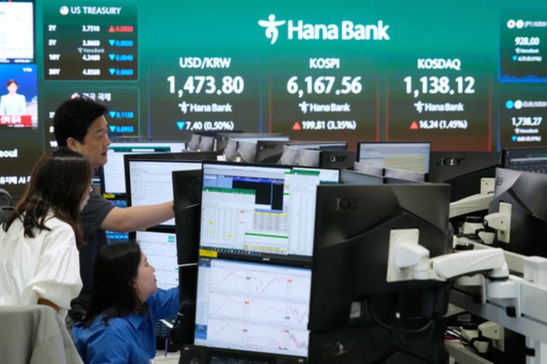Operadores observan monitores cerca de una pantalla en donde se despliega el Índice Compuesto de Precios de Acciones de Corea (KOSPI), en la sede del Banco Hana, el miércoles 15 de abril de 2026, en Seúl, Corea del Sur. (AP Foto/Ahn Young-joon)