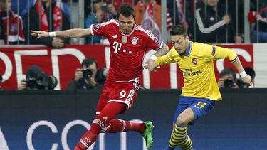 americateve | El jugador de Arsenal, Mesut Oezil, derecha, disputa un bal&oacute;n con el jugador de Bayern, Mario Madzukic, en un partido por la Liga de Campeones el martes, 11 de marzo de 2014, en Munich, Alemania. (AP Photo/Matthias Schrader)