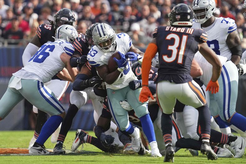 Javonte Williams (33), running back de los Cowboys de Dallas, corre con el balón mientras Kevin Byard III (31) y otros defensivos de los Bears de Chicago buscan detenerlo durante la primera mitad del partido de la NFL del domingo 21 de septiembre de 2025, en Chicago. (AP Foto/Nam Y. Huh)