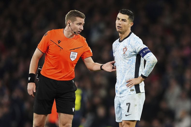 El árbitro Lawrence Visser (izquierda) conversa con Cristiano Ronaldo, de Portugal durante el partido de Liga de Naciones de la UEFA ante Escocia, en Hampden Park, en Glasgow, Escocia, el martes 15 de octubre de 2024. (Andrew Milligan/PA via AP)