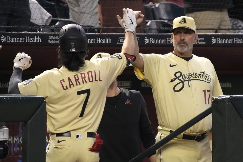 Corbin Carroll, de los Diamondbacks de Arizona, intercambia una palmada del manager Torey Lovullo (17) luego de conectar un jonrón en el juego del iernes 5 de mayo de 2023, ante los Nacionales de Washington (AP Foto/Rick Scuteri)