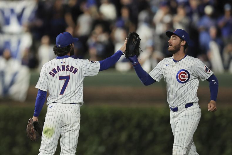Dansby Swanson, de los Cachorros de Chicago, a la izquierda, celebra con Cody Bellinger, de los Cachorros de Chicago, a la derecha, después de una victoria por 3-1 contra los Tigres de Detroit, el martes 20 de agosto de 2024, en Chicago. (AP Foto/Melissa Tamez)