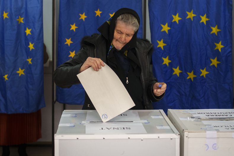 Una mujer deposita sus votos en las elecciones parlamentarias de Rumania, en Baleni, el domingo 1 de diciembre de 2024. (AP Foto/Vadim Ghirda)