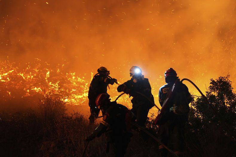 Bomberos luchan contra un gran incendio forestal en Kofinas, en la isla de Chios, en el Egeo oriental, en Grecia, la noche del domingo 22 de junio de 2205. (Pantelis Fykaris/Politischios.gr via AP)
