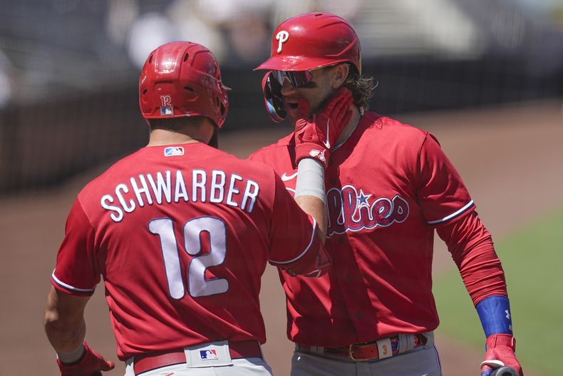 Kyle Schwarber, de los Filis de Filadelfia, celebra con su compañero Bryce Harper luego de batear un jonrón ante los Padres de San Diego, el miércoles 6 de septiembre de 2023 (AP Foto/Gregory Bull)