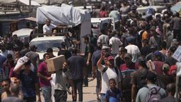 Palestinos con paquetes entregados por la Fundación Humanitaria de Gaza en Rafah, Franja de Gaza, el 15 de junio del 2025. (AP foto/Abdel Kareem Hana)