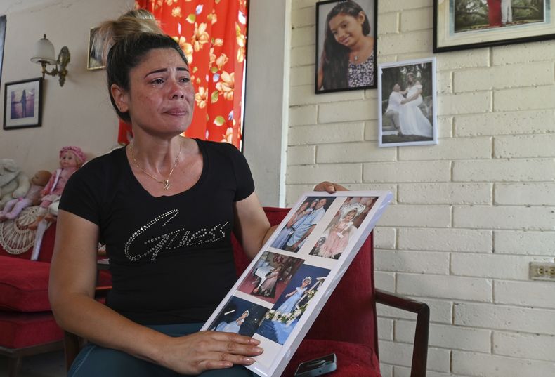 Heidy Sánchez, quien fue deportada de Estados Unidos a Cuba, llora mientras muestra fotos de su hija y su esposo, ciudadano estadounidense, en La Habana, el martes 6 de mayo de 2025. (AP Foto/Jorge Luis Baños)