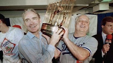 ARCHIVO - El mánager Tommy Lasorda (derecha) y el vicepresidente Fred Claire, de los Dodgers de Los Ángeles, alzan el trofeo de la Serie Mundial tras vencr a los Atléticos de Oakland, el 20 de octubre de 1987. (AP Foto/Bill Beattie)