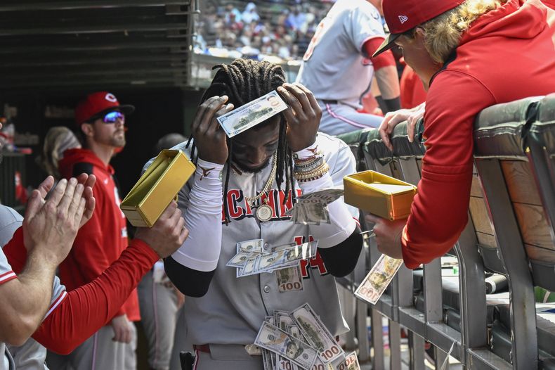 Elly De La Cruz, de los Rojos de Cincinnati, es bañado con dinero falso en el dugout después de conectar un jonrón de dos carreras durante la sexta entrada contra los Cachorros de Chicago, el domingo 1 de junio de 2025, en Chicago. (Foto AP/Matt Marton)