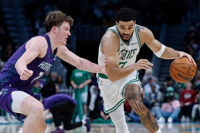 Jayson Tatum, derecha, de los Celtics de Boston, lelva el balón frente a Kon Knueppel, de los Hornets de Charlotte, durante la segunda mitad del juego de baloncesto de la NBA, el domingo 29 de marzo de 2026, en Charlotte, Carolina del Norte. (AP Foto/Nell Redmond)