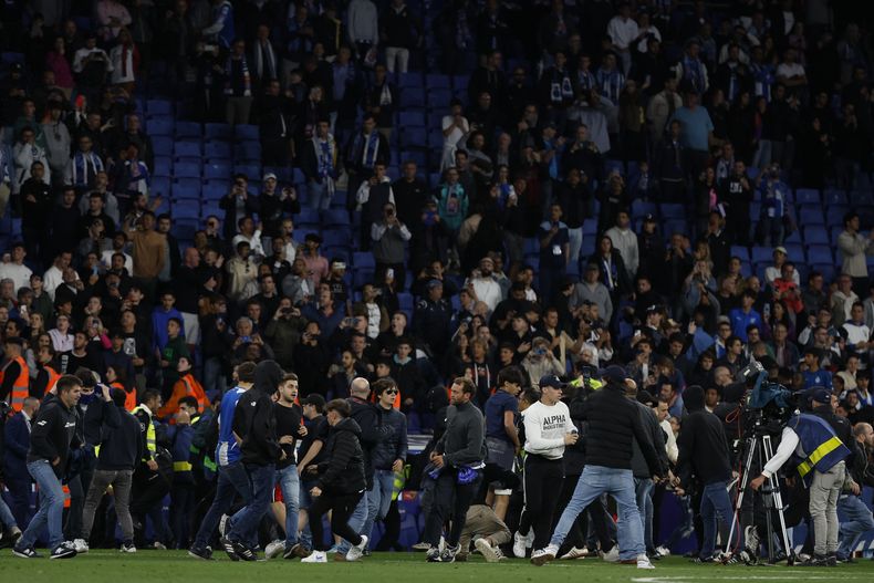 Aficionados irrumpen en la cancha del Espanyl tras la derrota 4-2 ante el Barcelona en el partido de la Liga española, el domingo 14 de mayo de 2023. (AP Foto/Joan Monfort)
