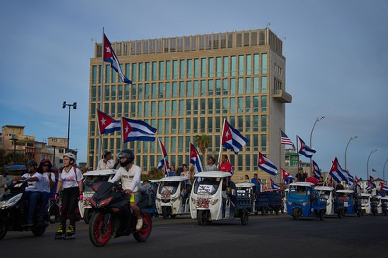 Varias personas pasan en vehículos eléctricos frente a la embajada de Estados Unidos durante una marcha juvenil antiimperialista organizada por el gobierno en La Habana, Cuba, el jueves 2 de abril de 2026. (AP Foto/Ramón Espinosa)