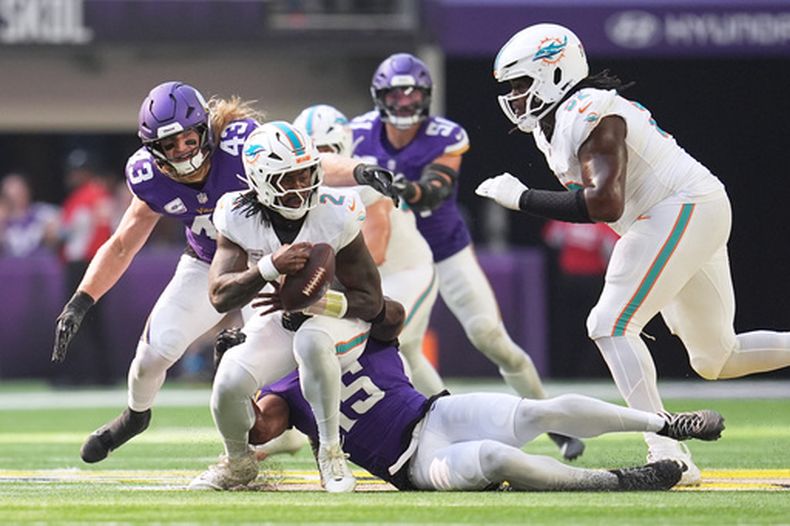 El quarterback de los Dolphins de Miami, Malik Willis (2), es capturado por el apoyador de los Vikings de Minnesota, Dallas Turner (15), durante la primera mitad de un partido de fútbol americano de la NFL el 4 de octubre de 2026, en Minneapolis. (Foto AP/Abbie Parr)
