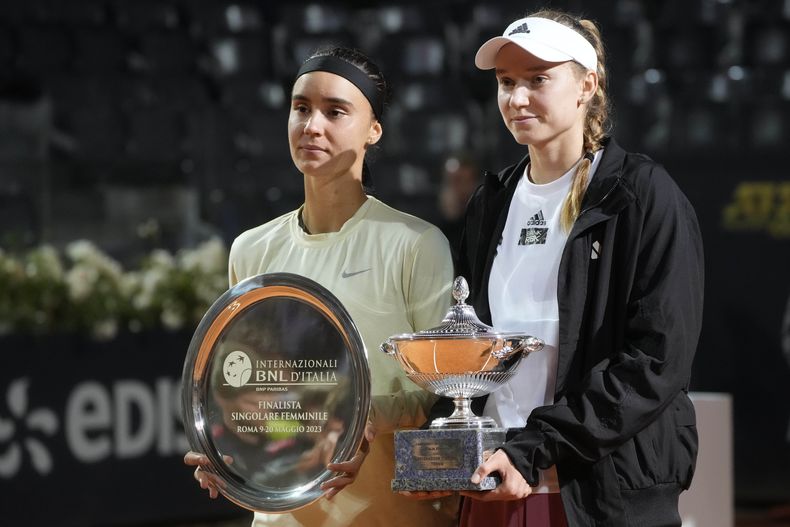 La kazaja Elena Rybakina (derecha) posa con el trofeo de campeona del Abierto de Italia, junto a la ucraniana Anhelina Kalinina, quien abandonó por lesión la final del domingo 21 de mayo de 2023 en Roma (AP Foto/Gregorio Borgia)