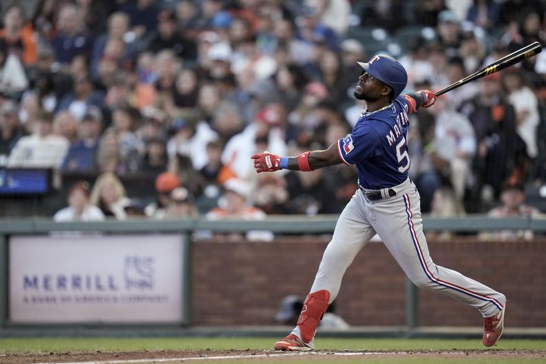 El cubano J.P. Martínez, de los Rangers de Texas, batea un elevado de sacrificio ante los Gigantes de San Francisco, el sábado 12 de agosto de 2023 (AP Foto/Godofredo A. Vásquez)