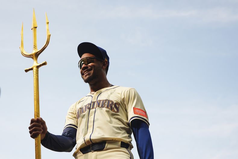 El jardinero cental de los Marineros de Seattle, Julio Rodríguez, sostiene el tridente para celebrar la victoria por 2-1 sobre los Atléticos en el juego de béisbol de Grandes Ligas del domingo 30 de marzo de 2025, en Seattle. (AP Foto/Lindsey Wasson)