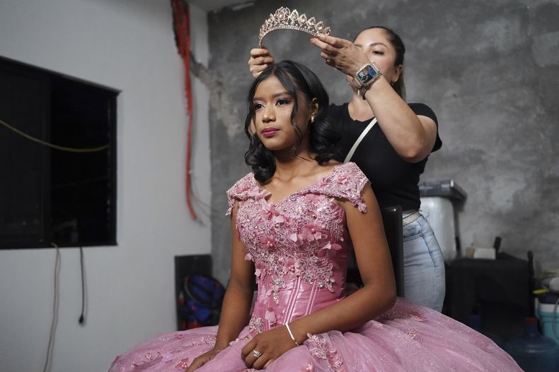 Una estilista prepara a Isela Santiago Morales para su Quinceañera, organizado por la comunidad después de que una invitación de su padre en medios sociales reuniera apoyos tras una fiesta inicial con escasa asistencia, en Axtla de Terrazas, México, el 23 de agosto de 2025. (AP Foto/Mauricio Palos)