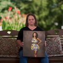 Christy Spivey con un retrato de su hija Tasia Fortune, en Marion, Kentucky, el 8 de septiembre del 2026. (AP foto/George Walker IV)