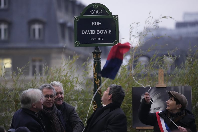 Autoridades develan un letrero de la rue David Bowie en París, el lunes 8 de enero de 2024. París nombró la calle en honor a Bowie en el que habría sido su cumpleaños 77. (Foto AP/Christophe Ena)