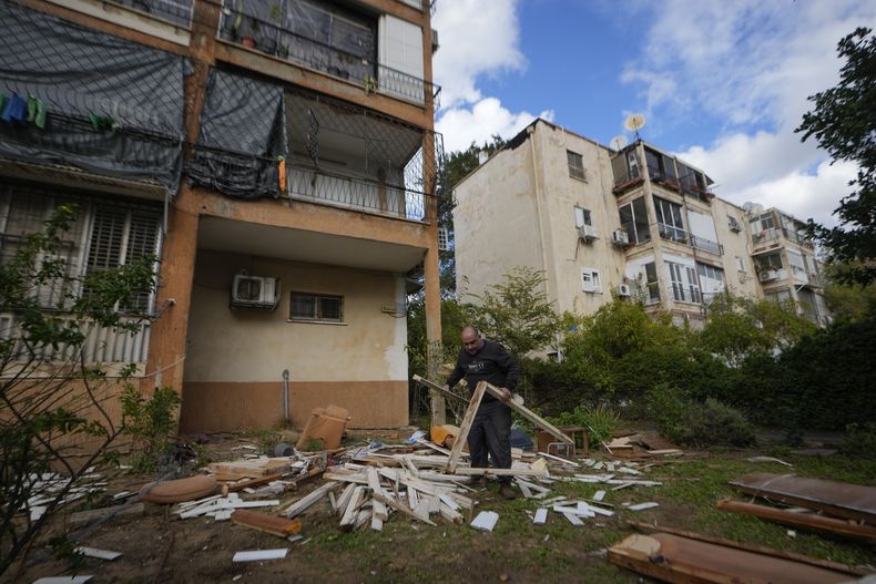 Un hombre trabaja junto a un edificio dañado cerca del lugar donde cayó un misil lanzado desde Yemen en el distrito de Jaffa, en Tel Aviv, Israel, el martes 31 de diciembre de 2024. (AP foto/Matias Delacroix)
