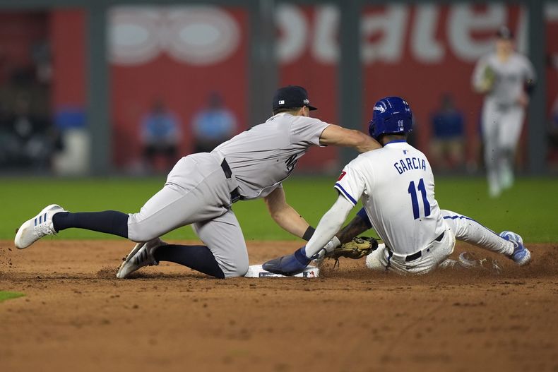 El venezolano Maikel García, de los Reales de Kansas City, es puesto out por Anthony Volpe, de los Yankees de Nueva York, en el cuarto juego de la serie divisional de la Liga Americana, el jueves 10 de octubre de 2024 (AP Foto/Charlie Riedel)