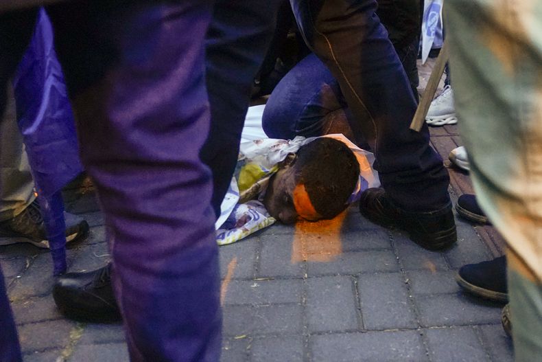 Una persona herida en el suelo tras el ataque a tiros en el que el candidato presidencial Fernando Villavicencio fue asesinado a la salida de un mítin electoral en un colegio en Quito, Ecuador, el miércoles 9 de agosto de 2023. (AP Foto/Juan Diego Montenegro)