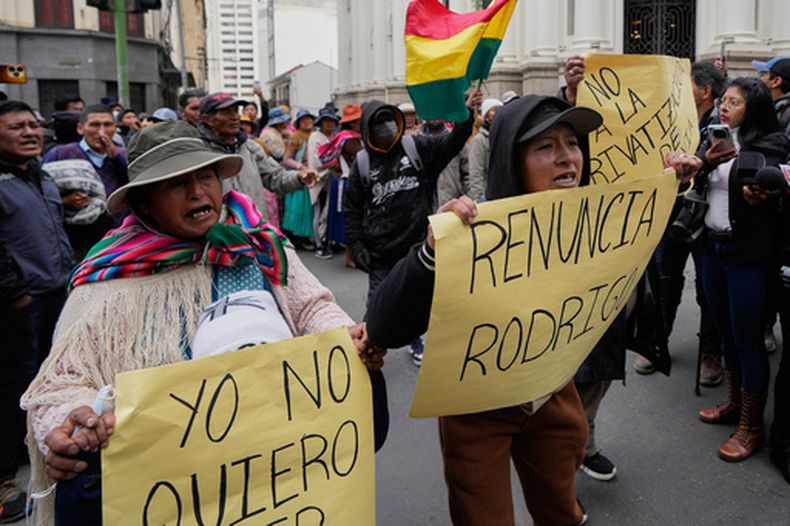 Manifestantes contrarios al gobierno sostienen carteles pidiendo la renuncia del presidente, Rodrigo Paz, en La Paz, Bolivia, el lunes 25 de mayo de 2026. (AP Foto/Juan Karita)