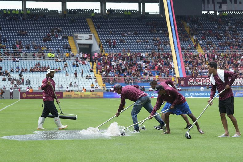 Cuadrillas de mantenimiento procuran remover el agua de la cancha previo al partido entre Venezuela y Argentina por las eliminatorias del Mundial, el jueves 10 de octubre de 204, en Maturín, Venezuela. (AP Foto/Ariana Cubillos)