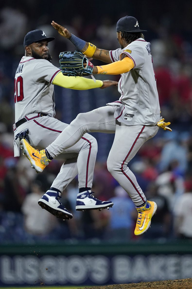 El dominicano Marcell Ozuna (izquierda) y el venezolano Ronald Acuña Jr. festejan la victoria de los Bravos de Atlanta sobre los Filis de Filadelfia, el martes 12 de septiembre de 2023 (AP Foto/Matt Slocum)
