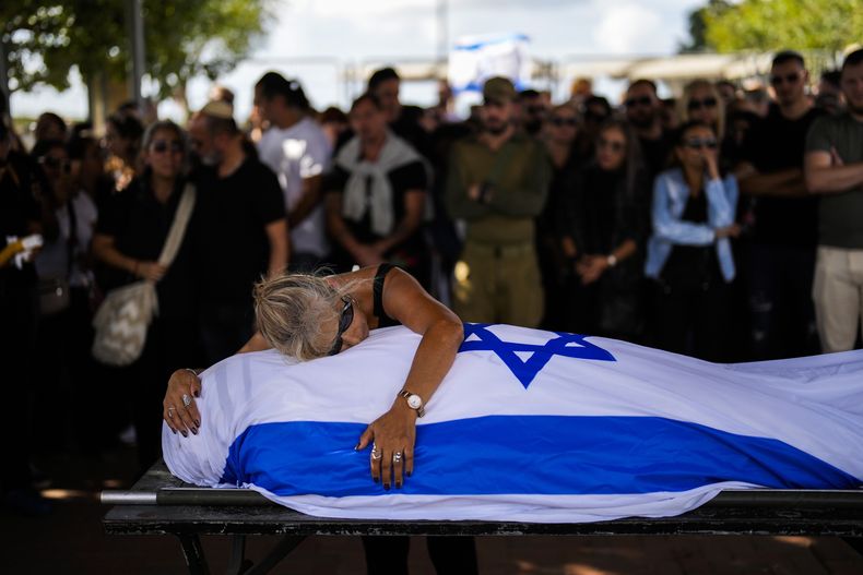 La madre de Antonio Macías llora sobre el cadáver de su hijo, cubierto con la bandera de Israel, en el cementerio Pardes Haim, en Kfar Saba, cerca de Tel Aviv, Israel, el 15 de octubre de 2023. Macias fue asesinado por insurgentes de Hamás cuando asistía a un festival de música en el sur de Israel a principios de mes. (AP Foto/Francisco Seco)