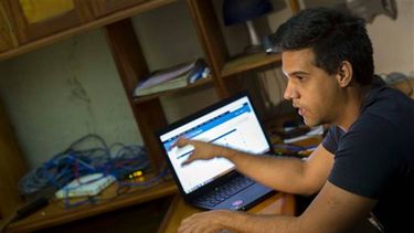 En  esta foto del 04 de enero 2015, Rafael Antonio Broche Moreno habla  durante una entrevista con The Associated Press, al lado de su  computadora en su casa de La Habana. Desconectado de la Internet real,  la red intranet es limitado, local y c