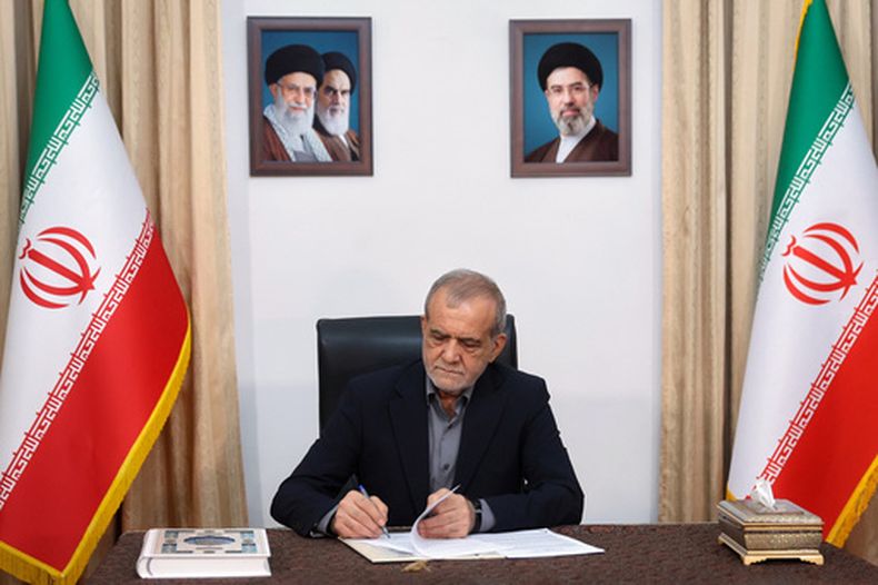 En la imagen, publicada por la oficina presidencial iraní, el presidente de Irán, Masoud Pezeshkian, firma un memorando de entendimiento firmado previamente por el presidente estadounidense Donald Trump con el fin de detener la guerra e iniciar conversaciones sobre un acuerdo más amplio, en Teherán, Irán, la mañana del jeves 18 de junio de 2026. (Oficina presidencial iraní vía AP)