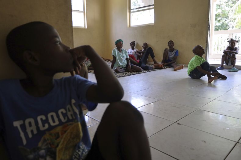 Niños ven una película después de recibir su medicación en el orfanato para niños con sida Caring for Haitian Orphans with AIDS, en Balan, Plaine-du-Nord, Haití, el miércoles 21 de mayo de 2025. (AP Foto/Patrice Noel)