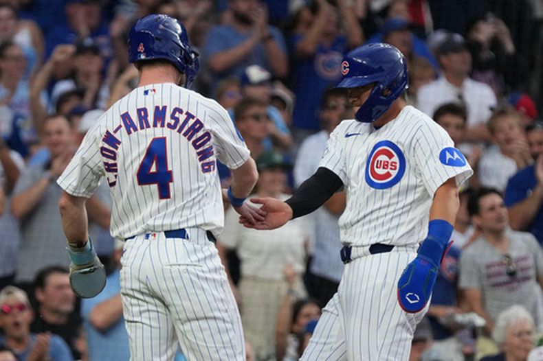 Pete Crow-Armstrong felicita a Seiya Suzuki, su compañero en los Cachorros de Chicago, luego que ambos anotaron ante los Tigres de Detroit el martes 21 de julio de 2026 (AP Foto/David Banks)